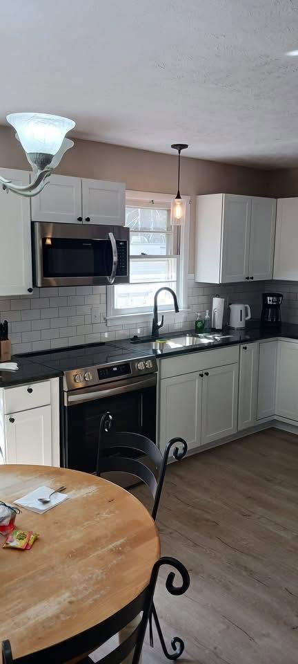 Remodeled kitchen with white cabinets, subway tile backsplash and stainless appliances