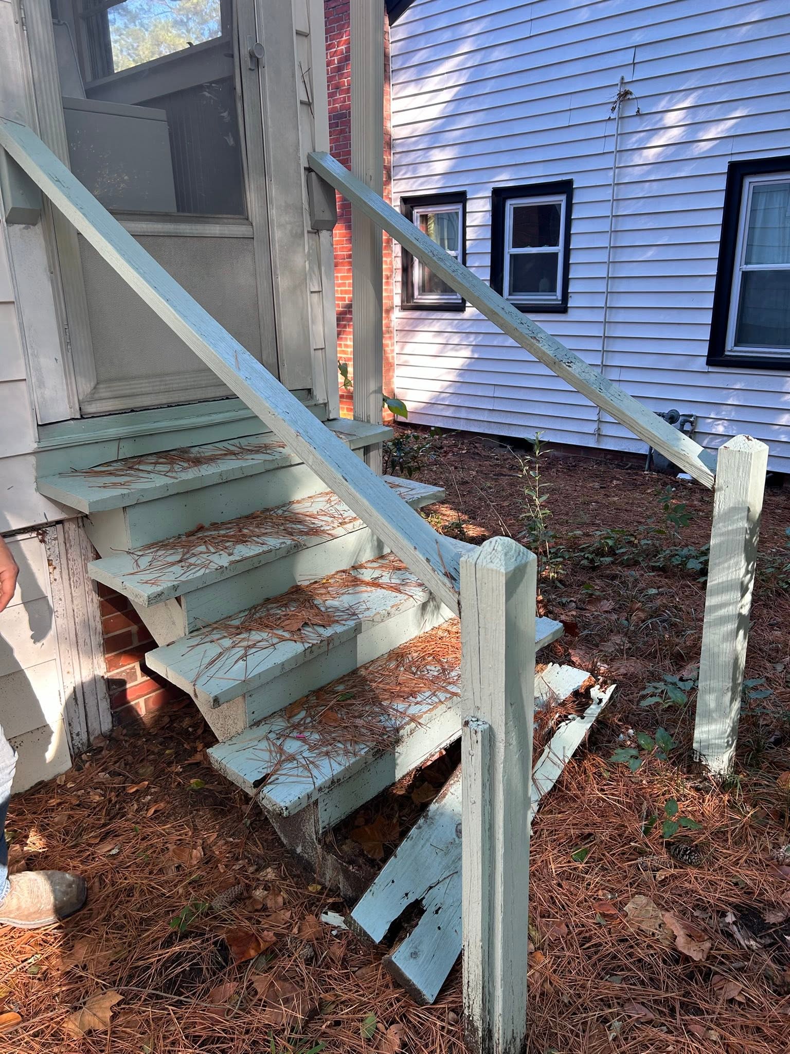 Deteriorated wooden deck stairs before replacement