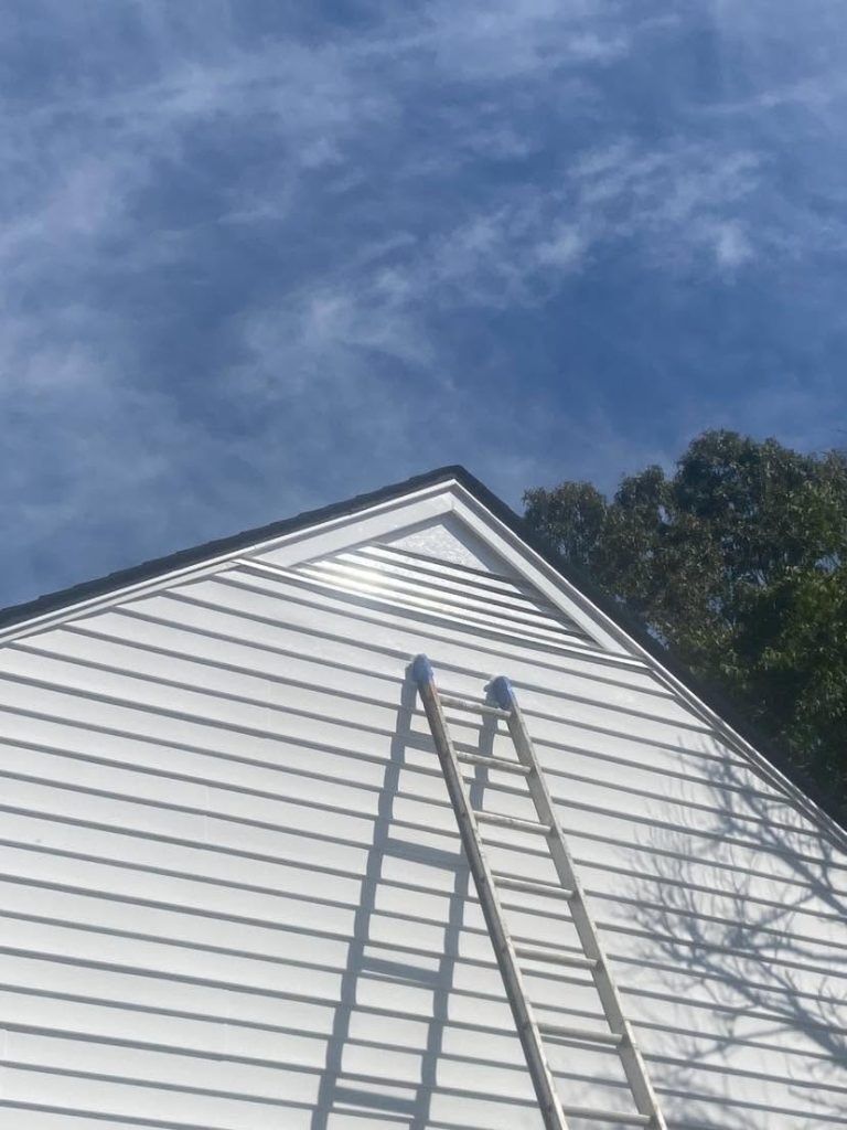 Ladder leaning against a home's gable during a roof inspection
